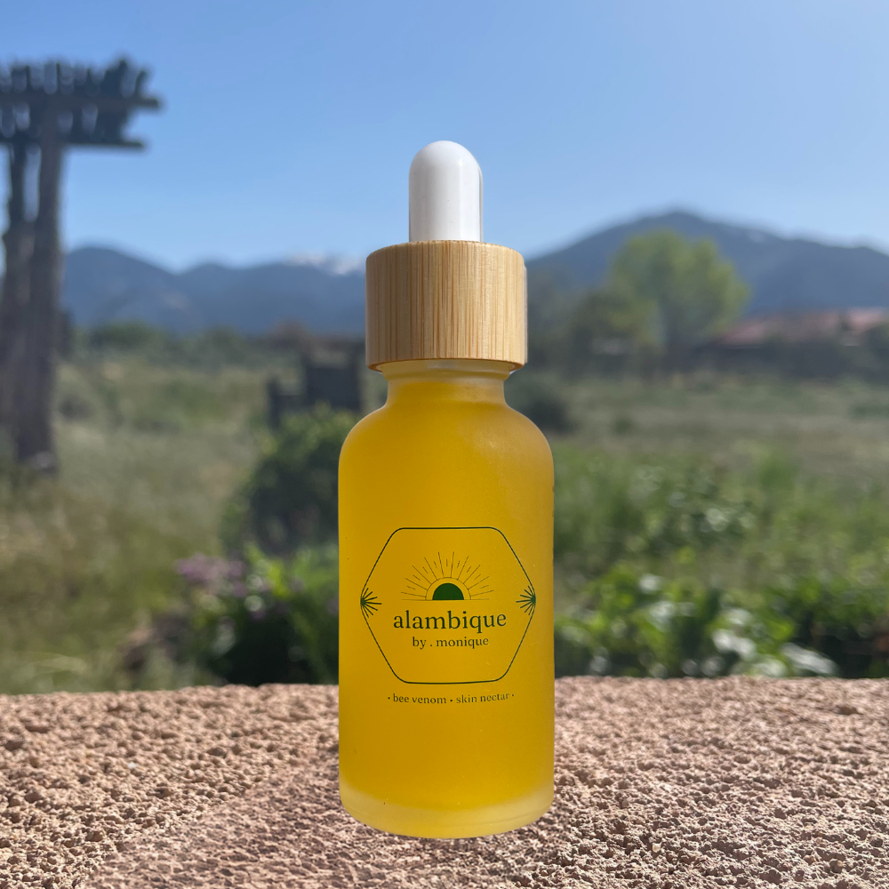 Alambique bee venom skincare serum with wild rosehip in a glass dropper bottle outdoors