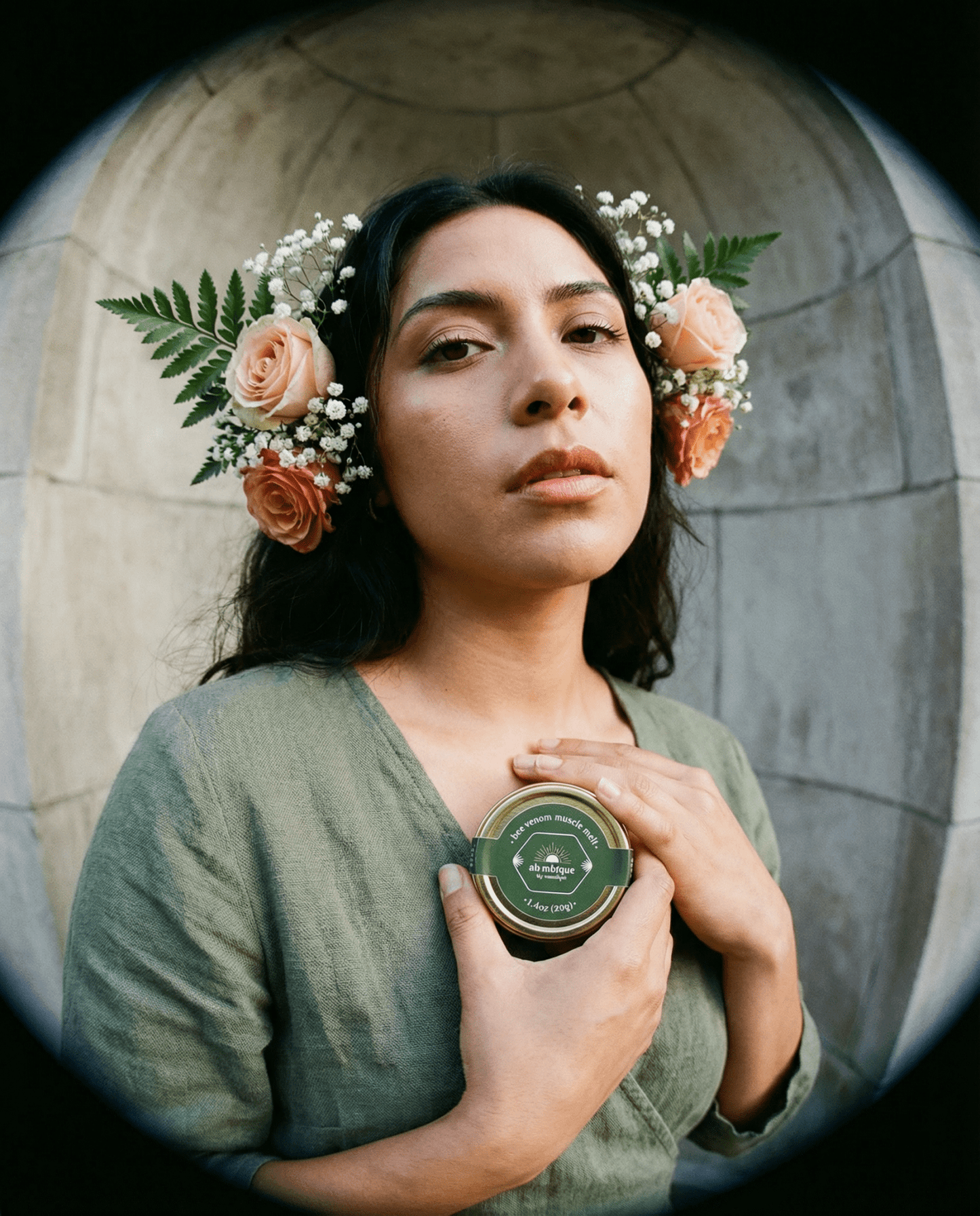 ethical bee venom • muscle melt •the • alambique. A Hispanic woman holding the product by her chest