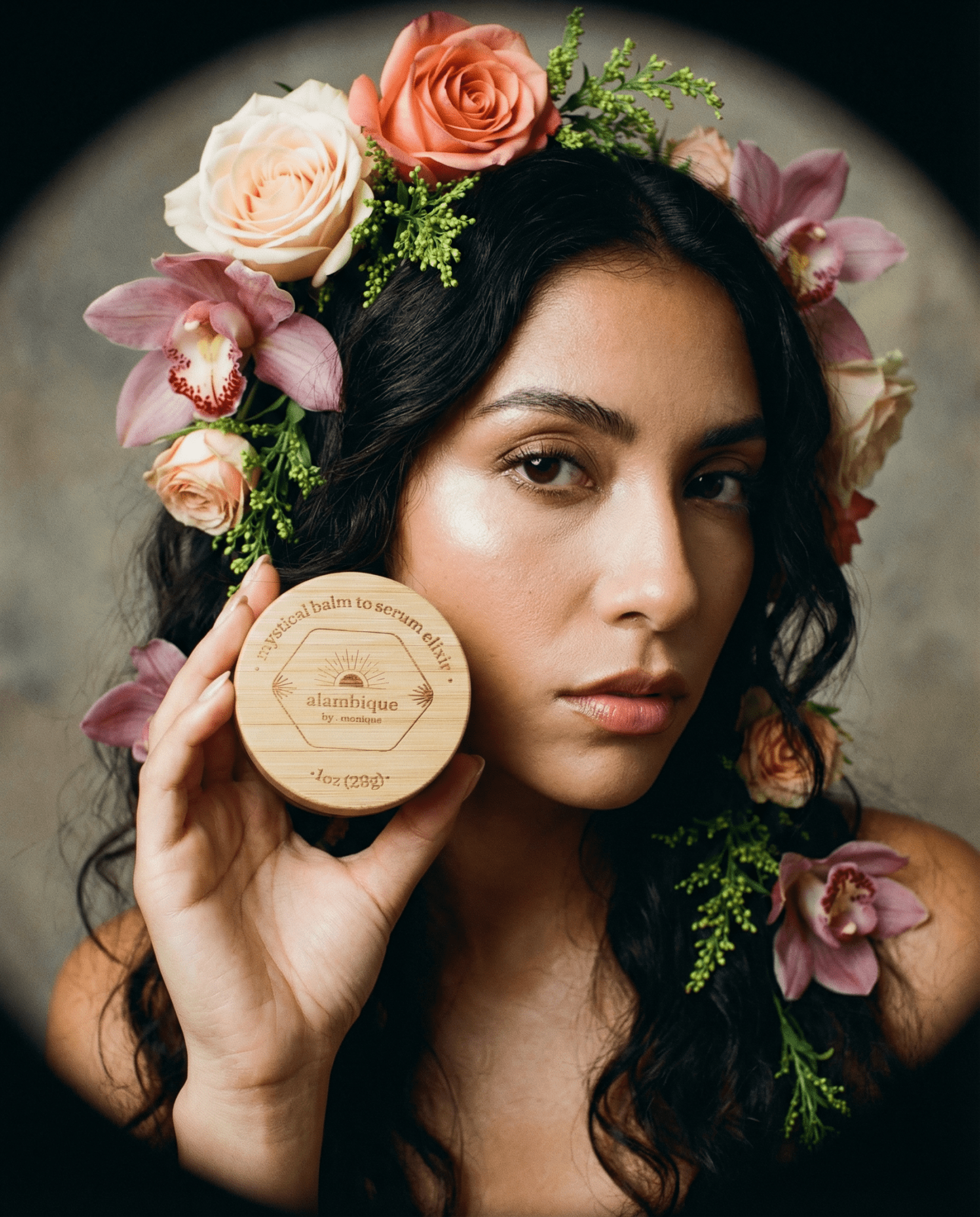 mystical balm to serum elixir next to a Hispanic model with a flower crown engraved bamboo cap