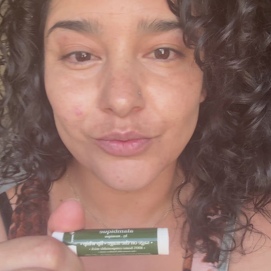 woman putting on a compostable lip balm stick