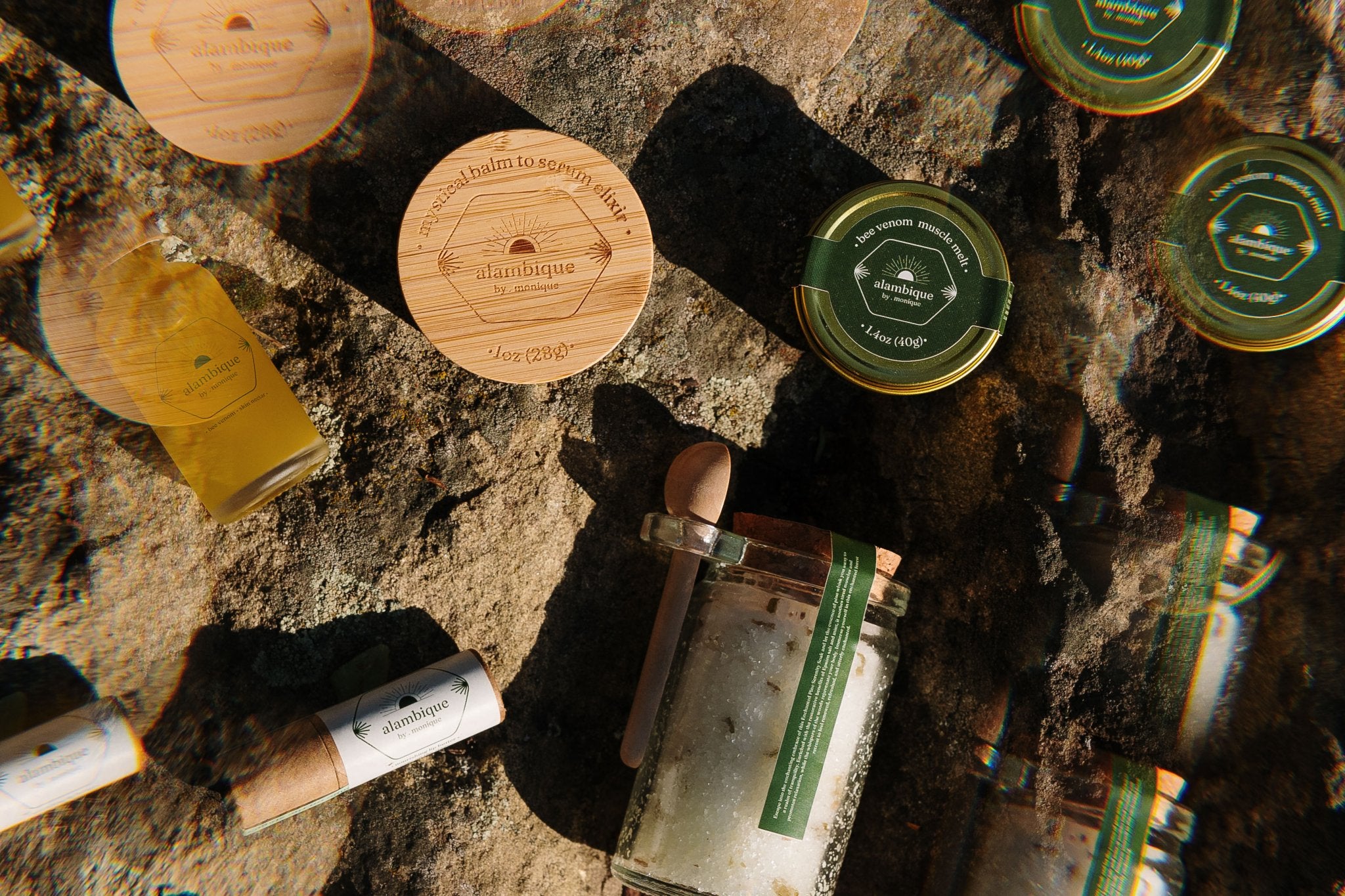 the alambique ritual collection bee venom skincare engraved bamboo cap on a rock in nature